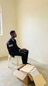 Founder of Fecane Child Foundation sitting inside their newly acquired, humble first office space in Wakiso.