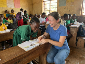 A Fecane Child Foundation volunteer teacher helping a primary student with their studies in Wakiso.